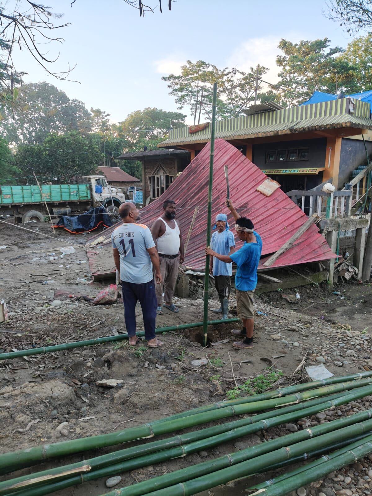 Neighbours lifting a roof panel into place on a home for another family